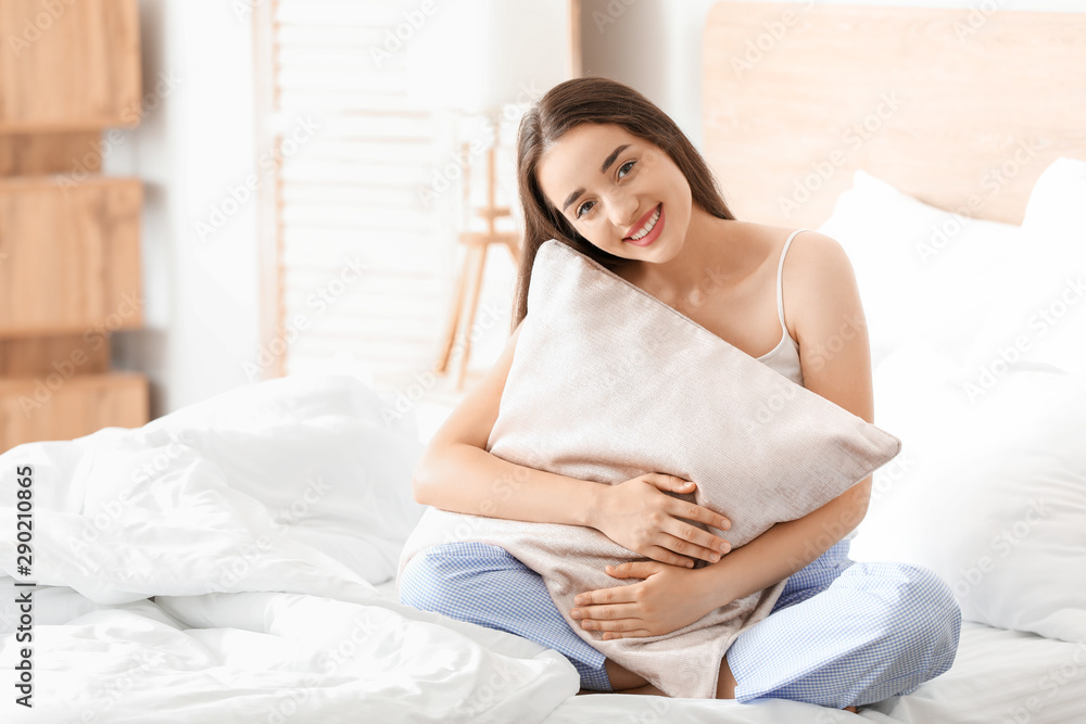 卧室里年轻漂亮女人的早晨