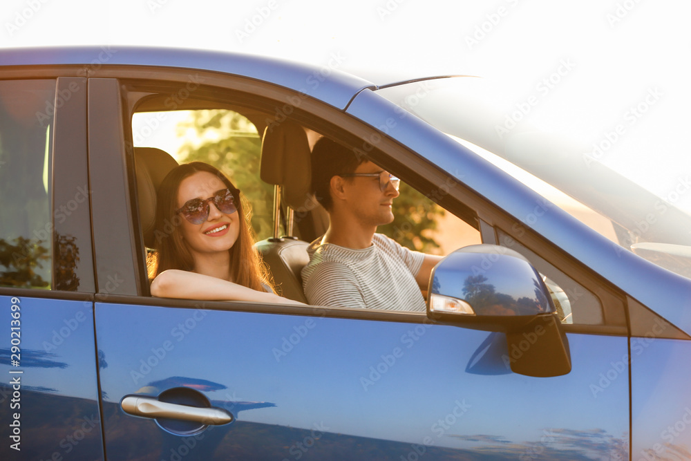 Happy couple sitting in their new car