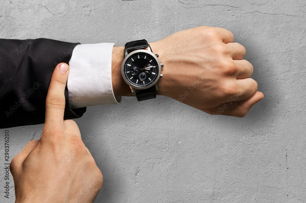 Businessman pointing at hand watch