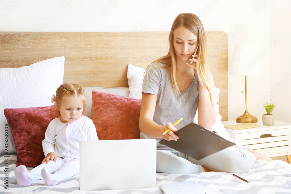 Working mother with her daughter  in bedroom at home