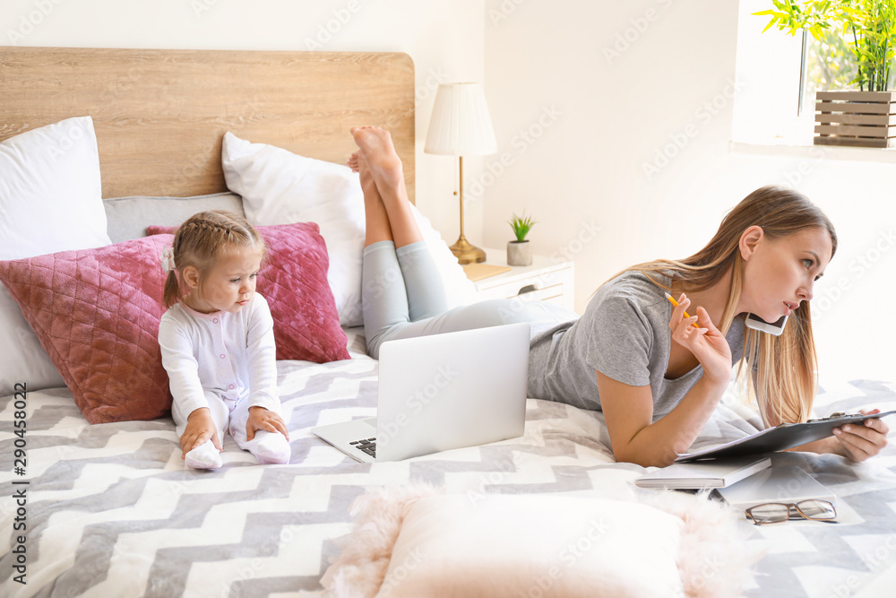 Working mother with her daughter  in bedroom at home