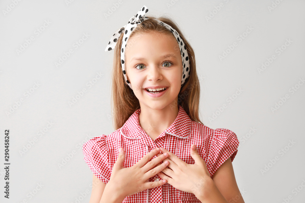 Portrait of excited little girl on light background