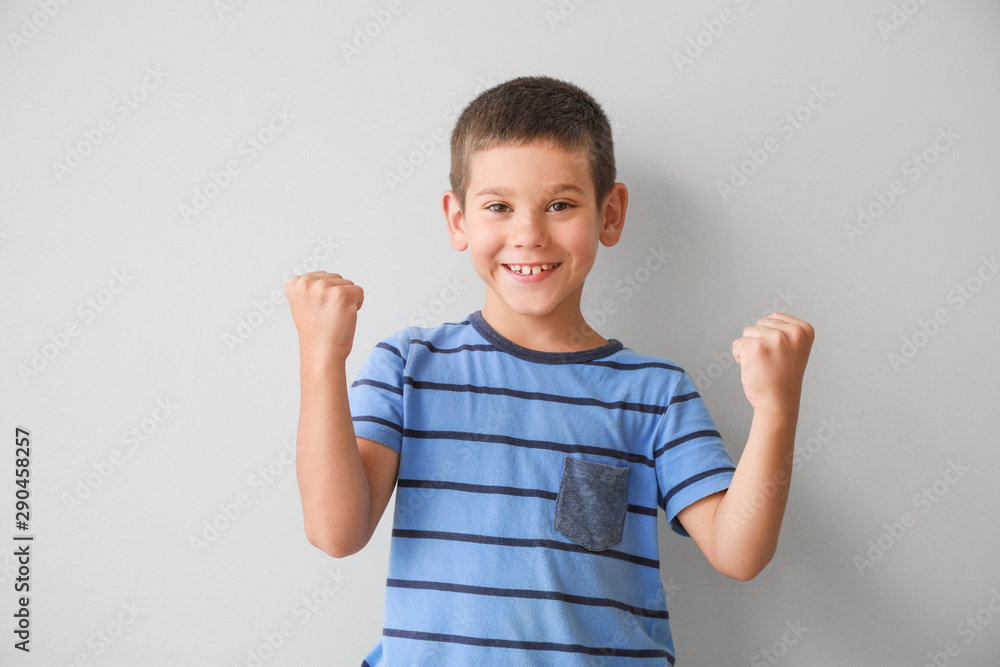 Portrait of happy little boy on light background