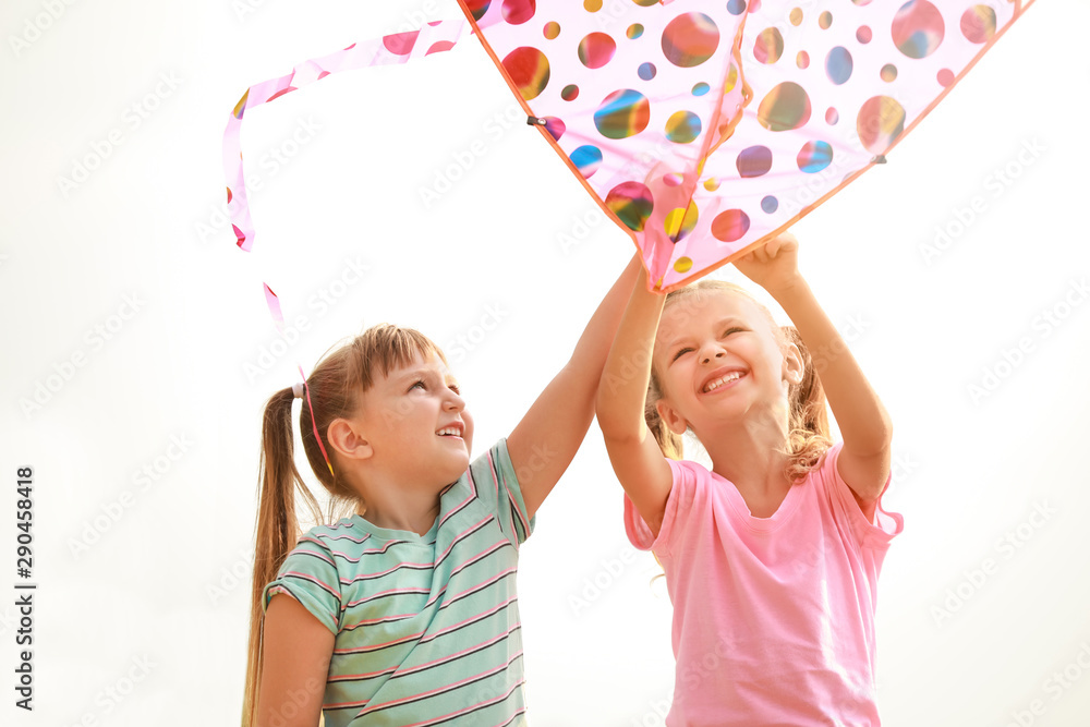 Little girls flying kite outdoors