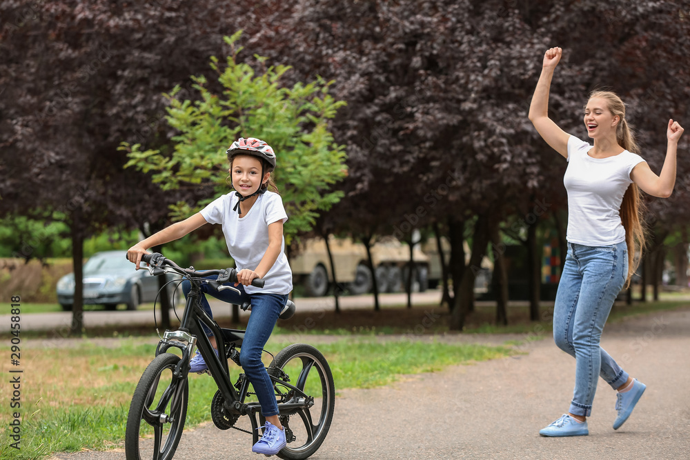 Mother proud of her daughter who learned to ride bicycle outdoors