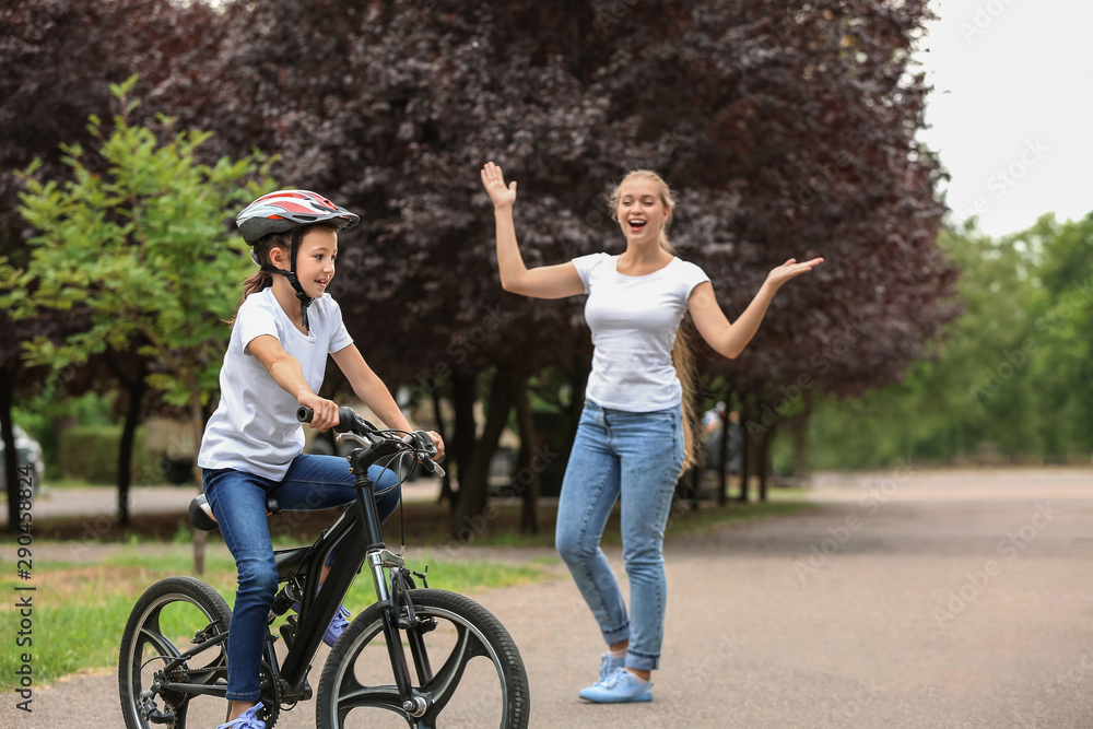 Mother proud of her daughter who learned to ride bicycle outdoors