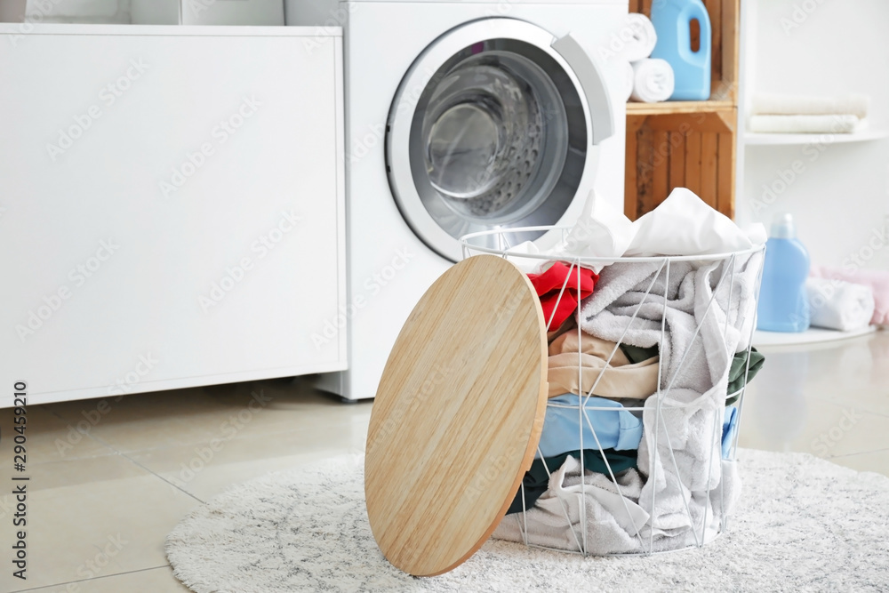 Basket with dirty laundry on floor in bathroom