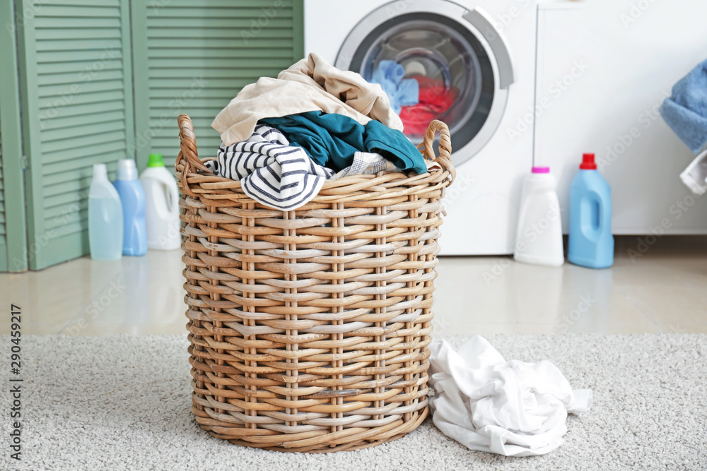 Basket with dirty laundry on floor in bathroom