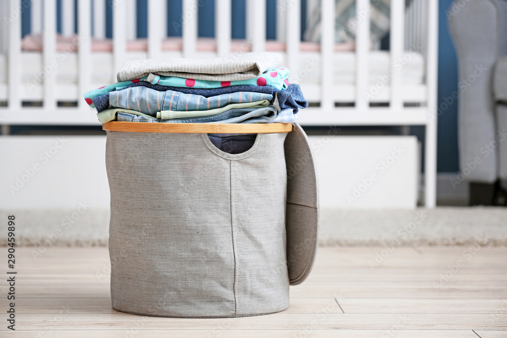 Basket with laundry on floor in baby room