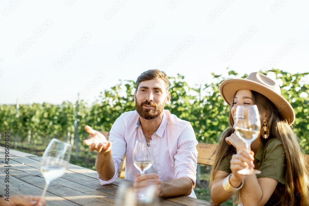 一群年轻人坐在户外餐桌旁喝酒聊天