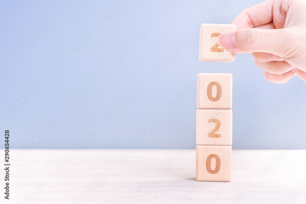 Abstract 2020 & 2019 New year countdown design concept - woman holding wood blocks cubes on wooden t