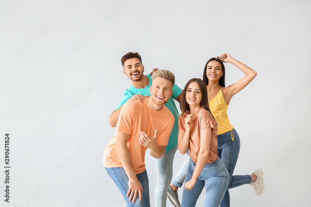 Group of young people in stylish casual clothes on light background