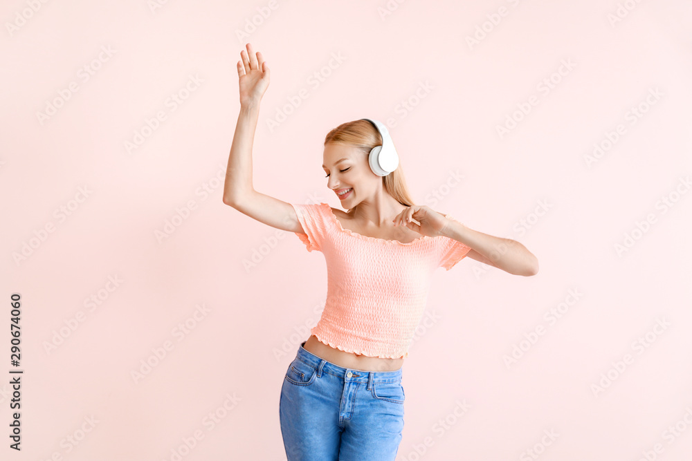 Beautiful young woman listening to music on color background