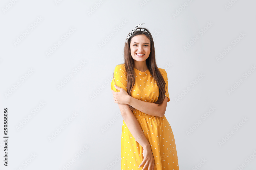 Portrait of happy young woman on grey background