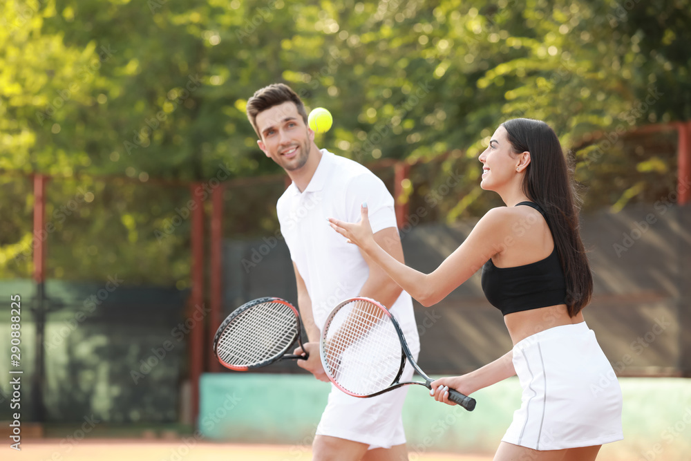 Young couple playing tennis on court