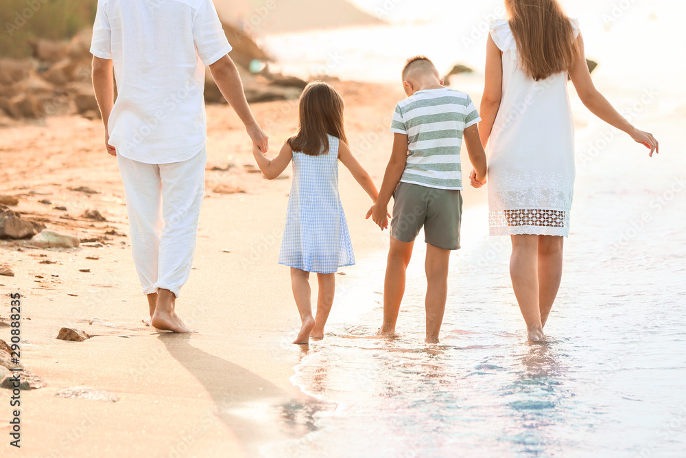 Happy family walking on sea beach