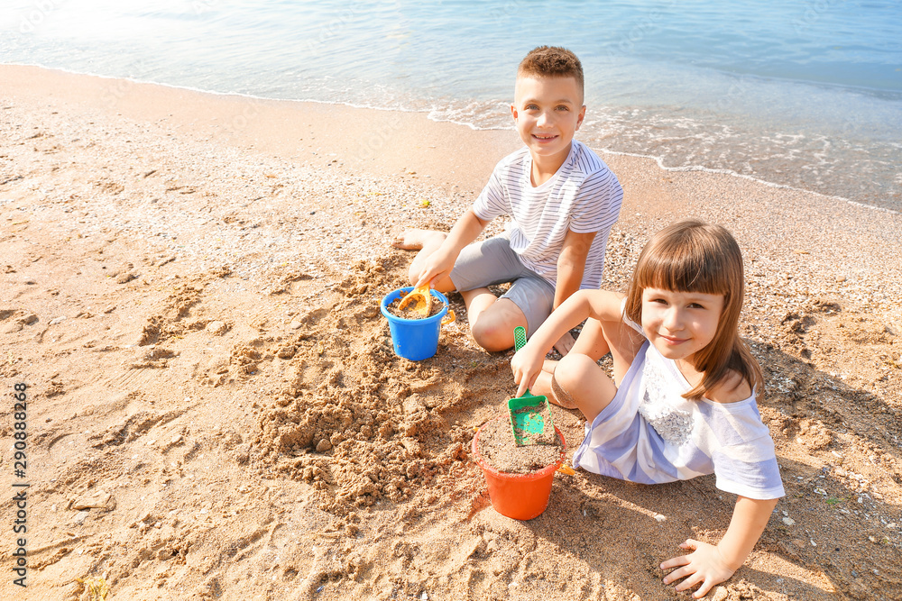 Little children playing with sand on sea beach