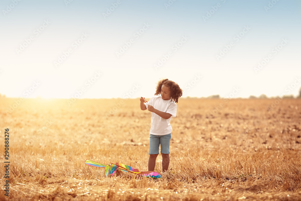 Little African-American girl flying kite outdoors