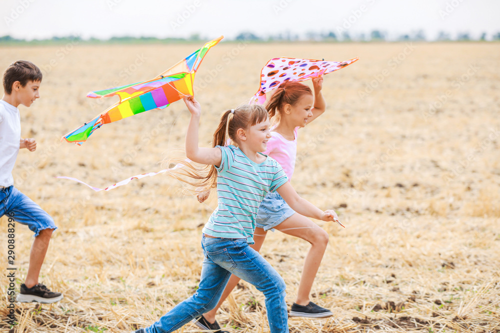 Little children flying kites outdoors