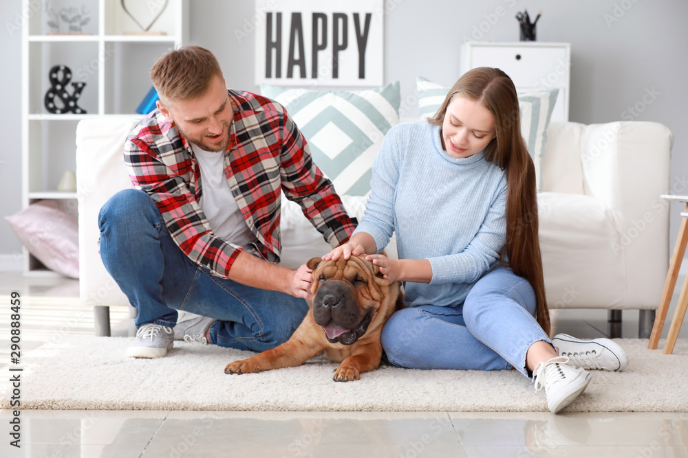 Happy couple with cute dog at home