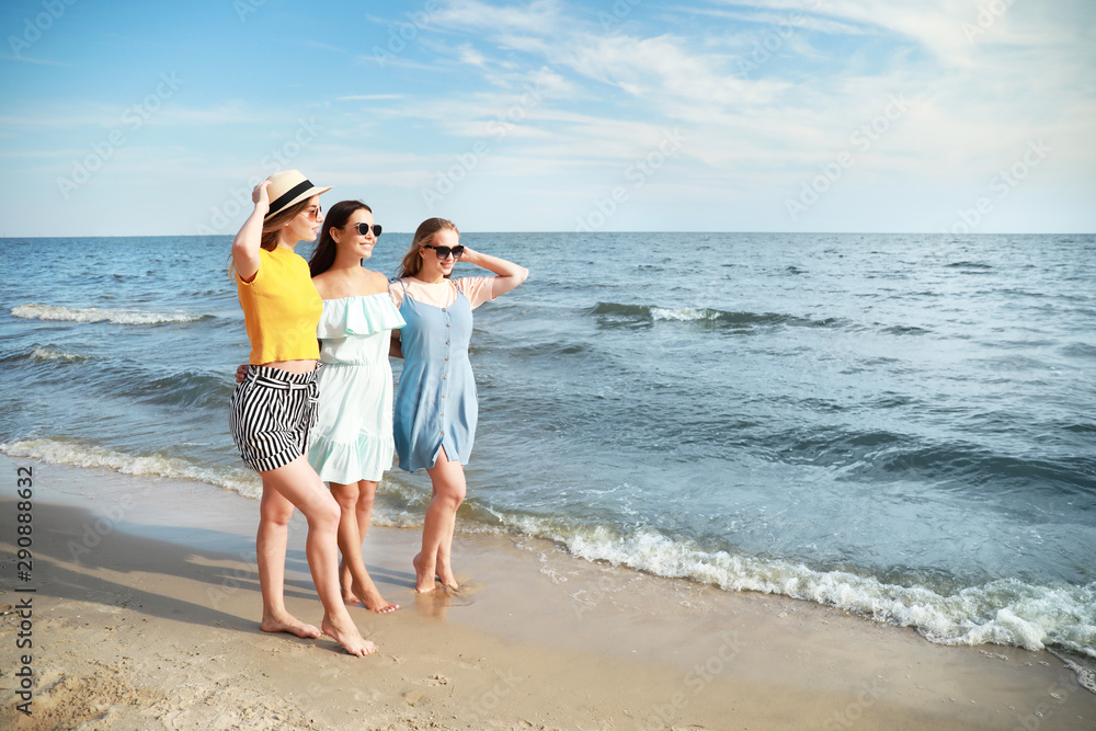 Happy young women on sea beach at resort