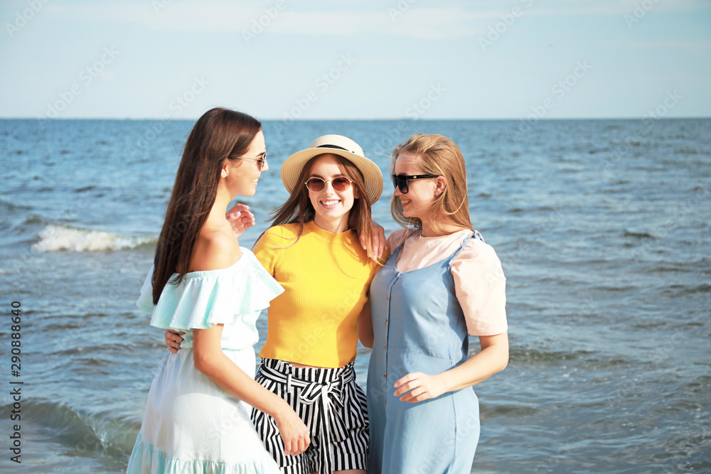 Happy young women on sea beach at resort