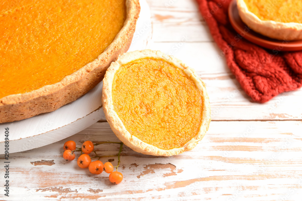 Tasty pumpkin pies on wooden background