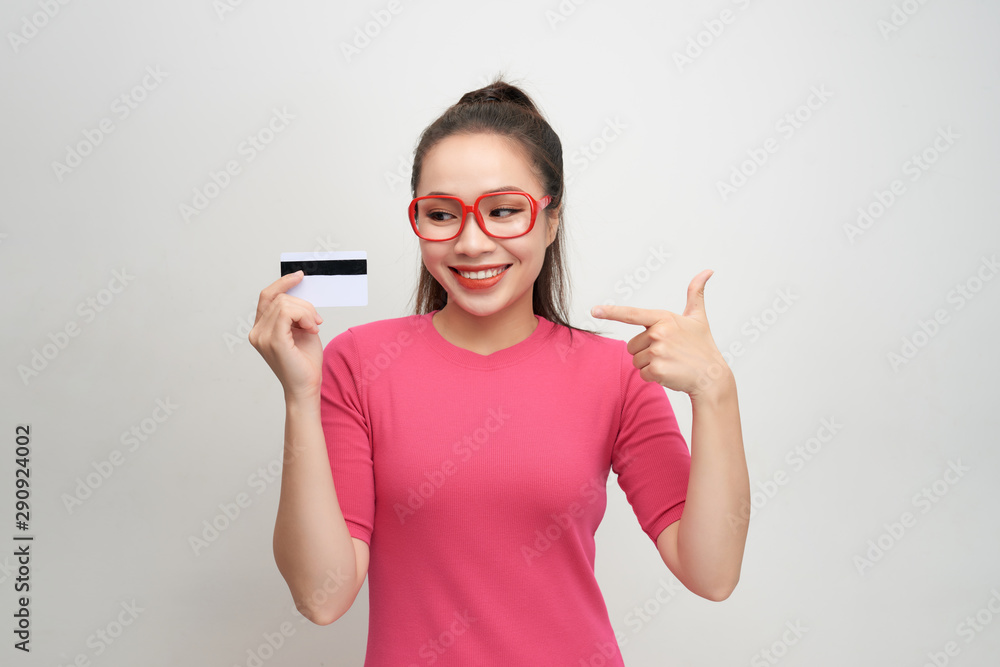 Photo of pretty young woman isolated over white background. Looking camera winking holding credit ca