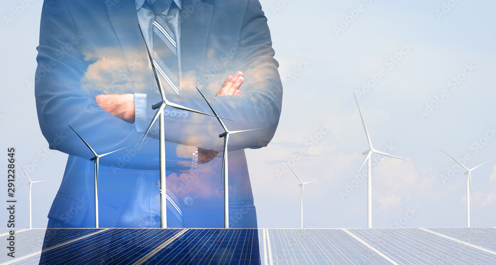 Double exposure graphic of business people working over wind turbine farm and green renewable energy