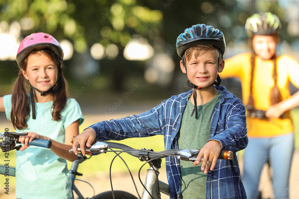 Cute children riding bicycles outdoors