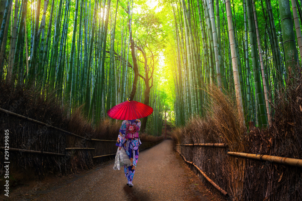 Bamboo forest at Arashiyama with woman in traditional kinono and umbrella. Japan