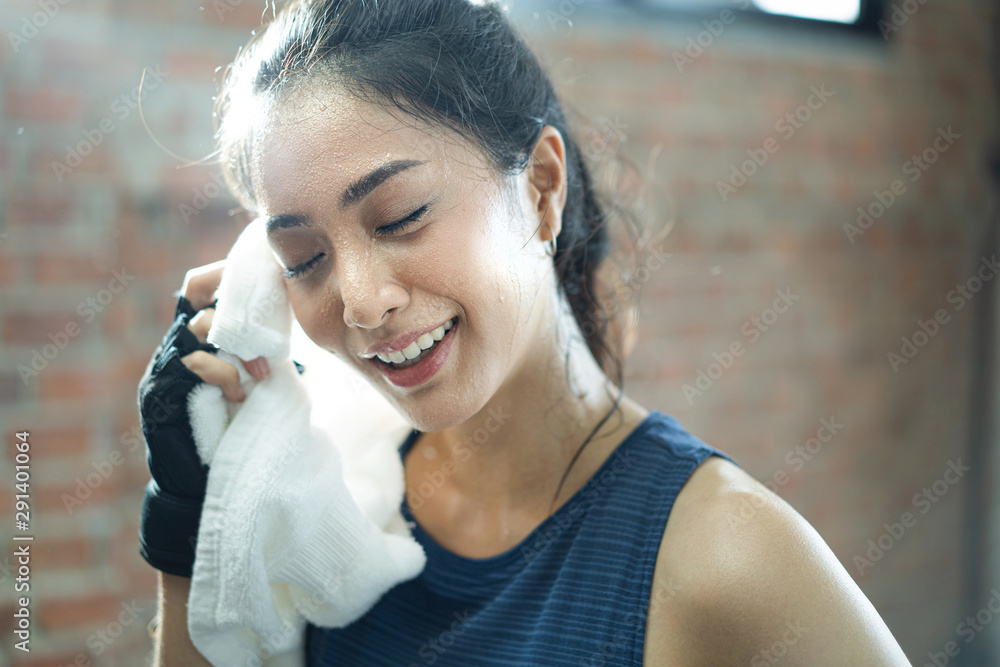 在健身房锻炼的亚洲女孩累了，脸上都是汗。