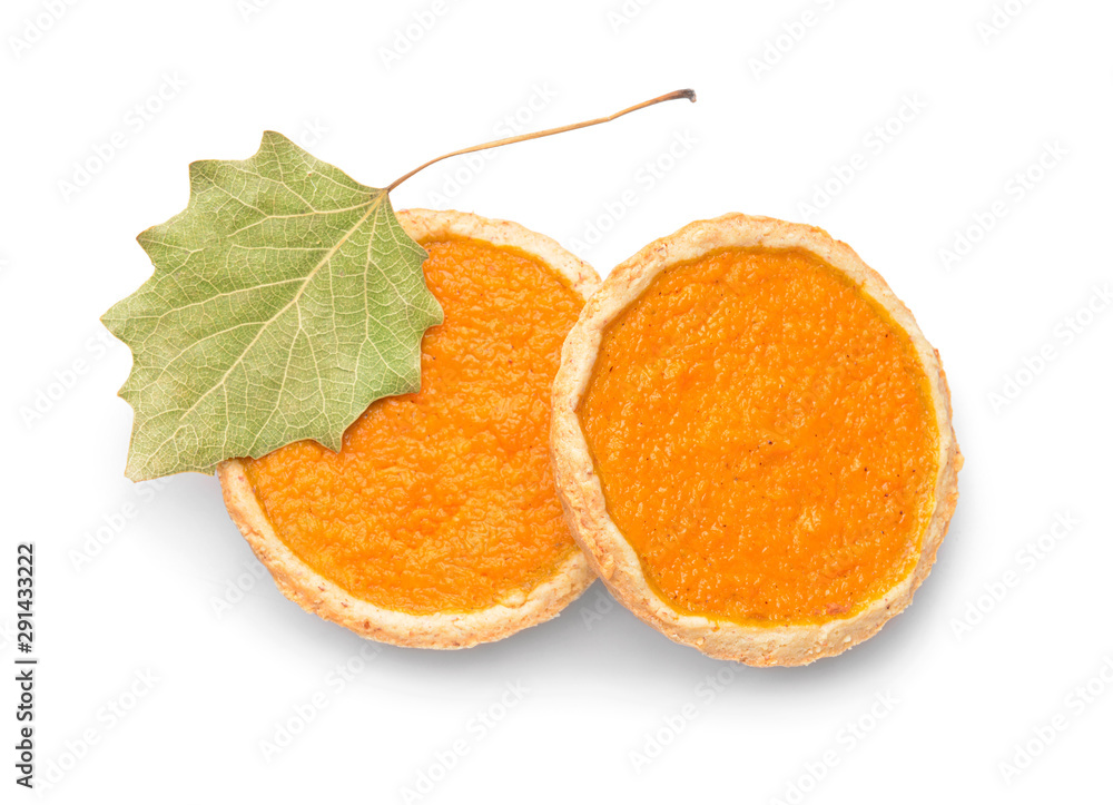 Tasty pumpkin pies on white background