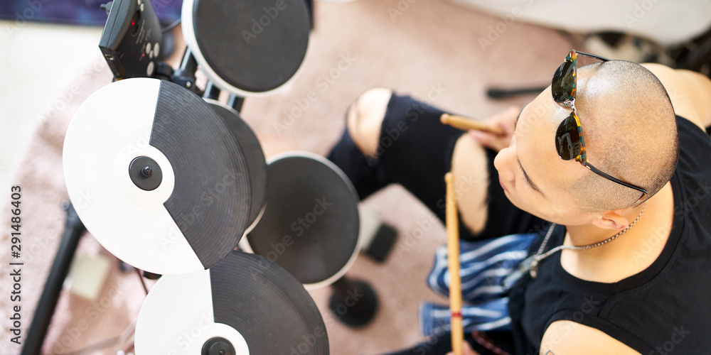 young asian percussionist playing drums