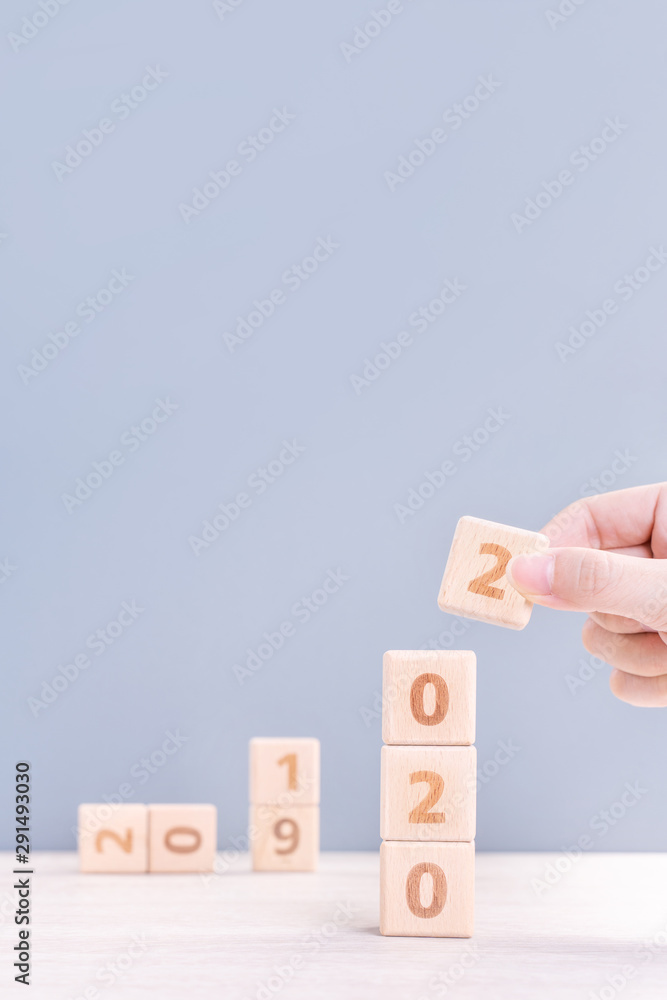 Abstract 2020 & 2019 New year countdown design concept - woman holding wood blocks cubes on wooden t