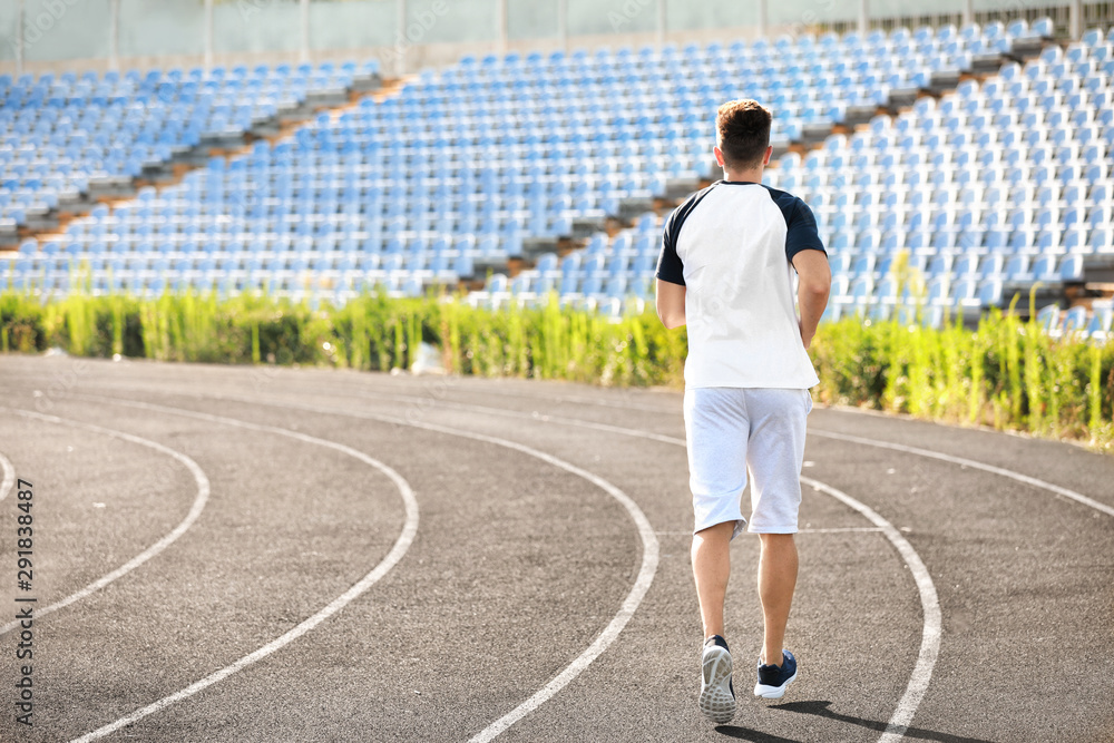 Sporty young man running at the stadium