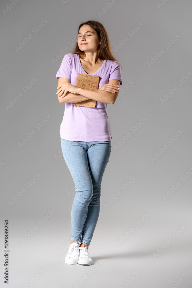 Young girl with book on grey background