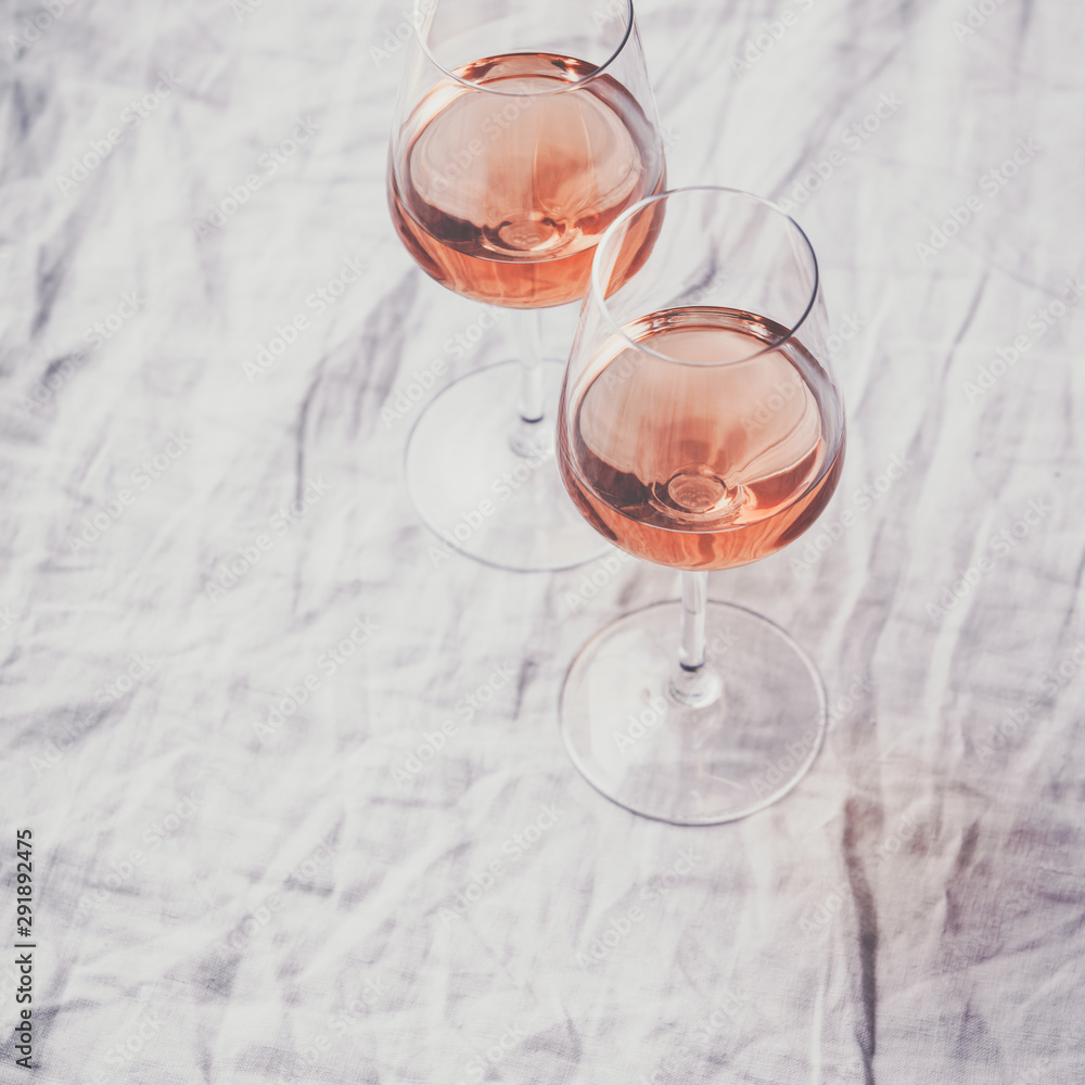 Rose wine in glasses on white linen cloth