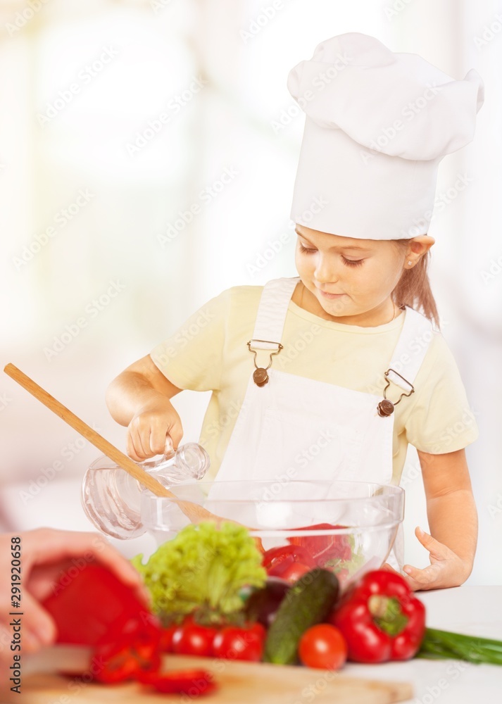 Portrait of adorable little girl preparing healthy food at kitchen