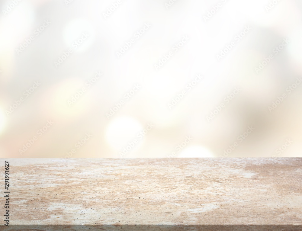 Brown desk in a white empty room lit by the sun