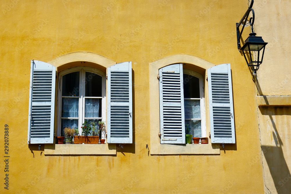 facade of mediterranean building with colorful shutter 