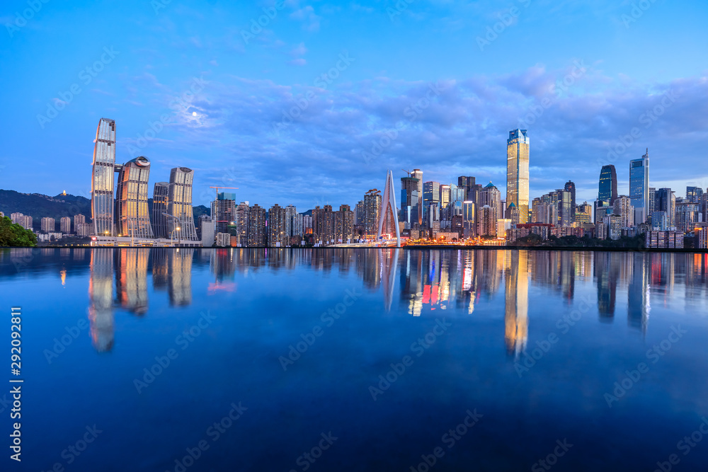 重庆天际线和现代城市摩天大楼，夜晚水的倒影，中国。