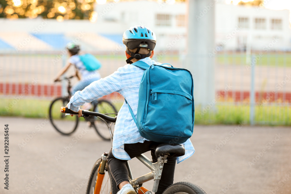 Cute boy riding bicycle outdoors