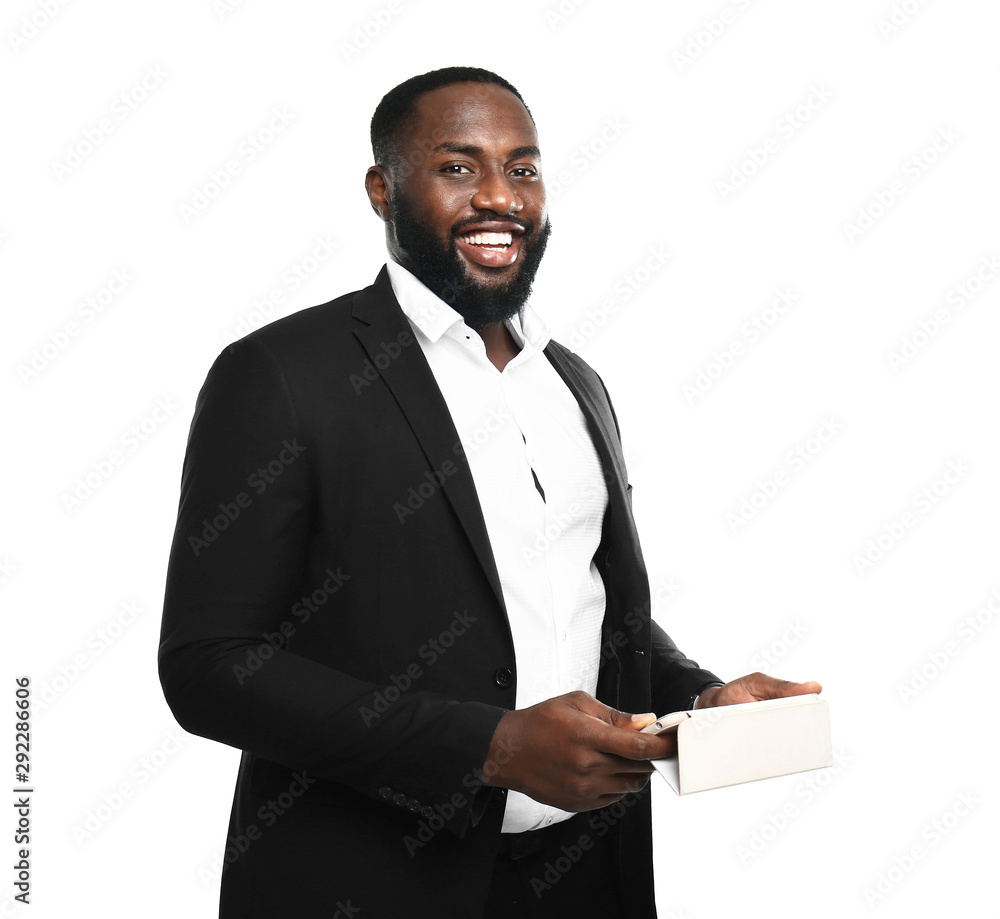 Handsome African-American businessman with mobile phone on white background