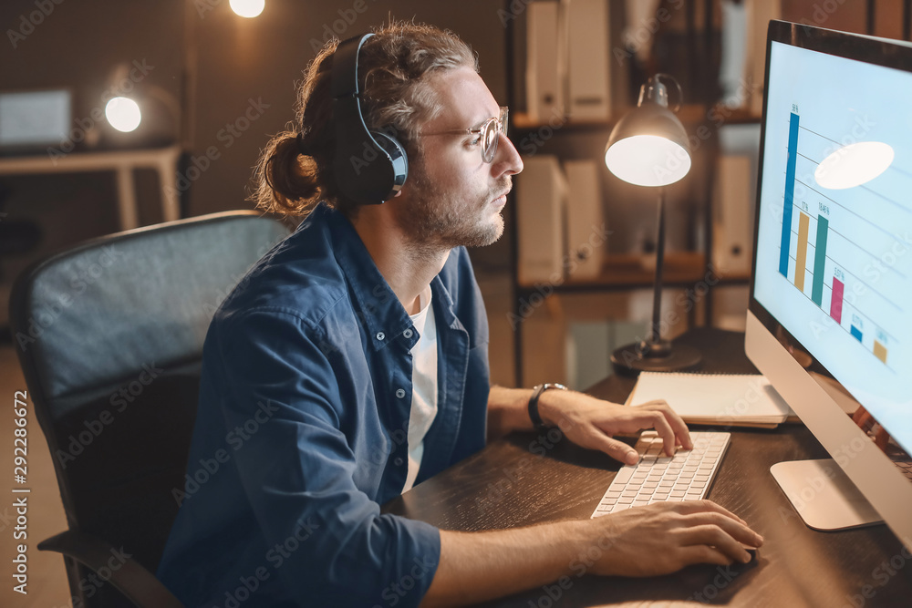 Man trying to meet deadline in office late in evening