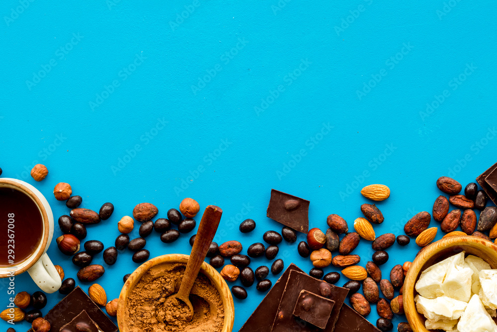 Chocolate bars and nuts on blue table background top view mockup