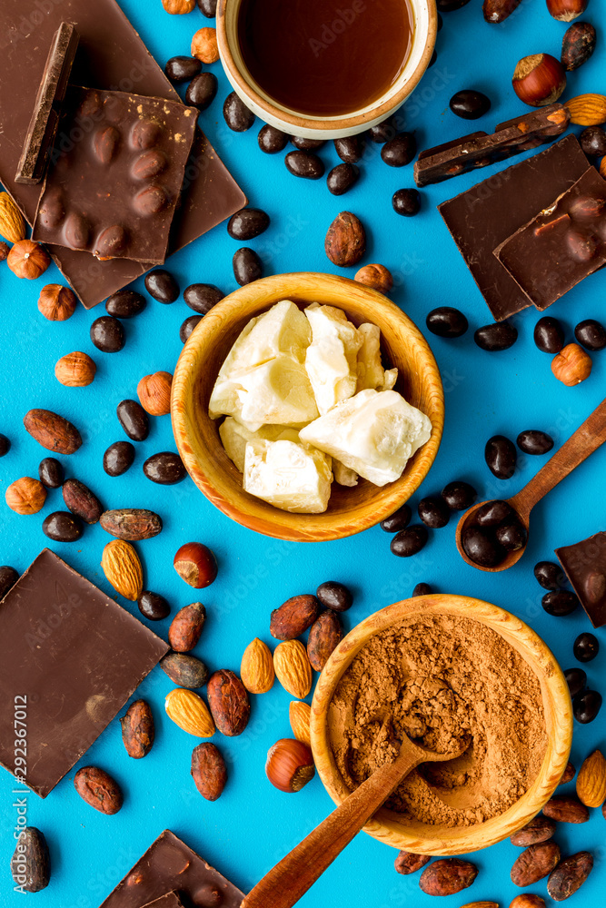 Different variety of chocolate and hazelnut on blue background top view