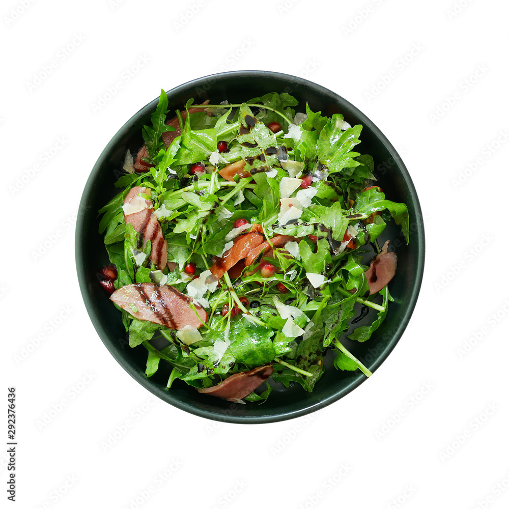 Top view of fresh green vegetable salad with sliced smoked duck and red pomegranate seeds and Parmes