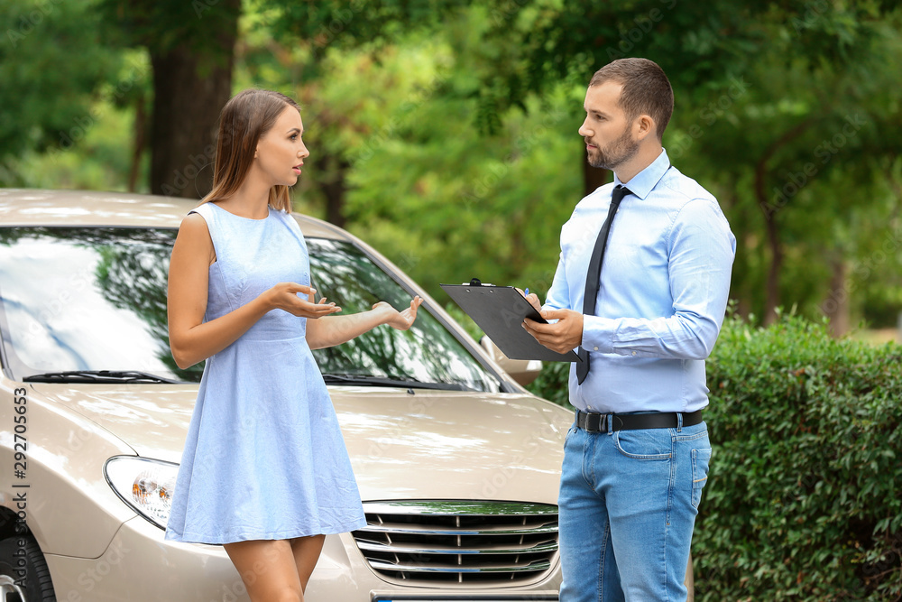 Young woman and insurance agent near damaged car outdoors