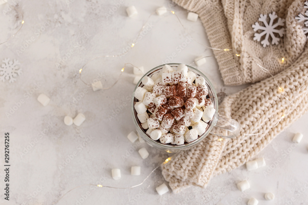 Cup of hot chocolate with marshmallows on light background